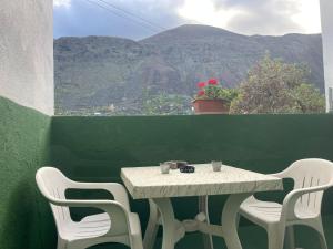 a table and chairs with a view of a mountain at Apartamento Tabaiba in Tamaduste