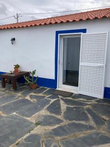 a patio with a door and a table next to a building at Casa do Monte - Esperança in Esperança