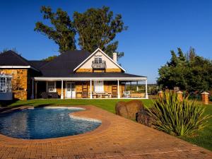 a house with a swimming pool in the yard at Retief Guest Farm in Kroonstad