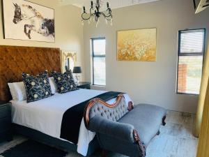 a bedroom with a bed with a chair and a chandelier at Retief Guest Farm in Kroonstad