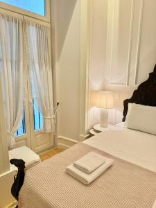 a white bedroom with a bed with two towels on it at Charming apartment on Rua Augusta in Lisbon