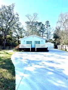 a white house with a porch and a driveway at Ocean Springs Cottage 2 Bedroom 2 Bath in Ocean Springs