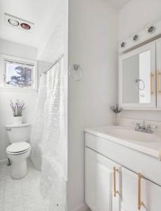 Baño blanco con aseo y lavamanos en Luxury NY Getaway with Free Garage Parking in PRIME Location en White Plains