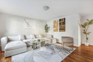 Sala de estar blanca con sofá blanco y mesa en Luxury NY Getaway with Free Garage Parking in PRIME Location en White Plains