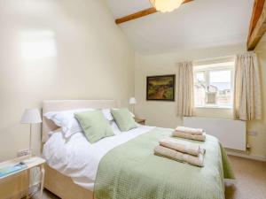 a bedroom with a large white bed with towels on it at 3 Bed in Blandford Forum 83014 in Woolland