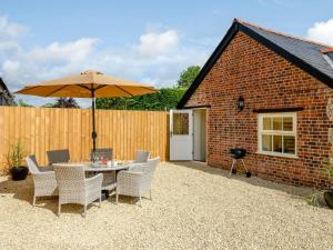 a patio with a table and chairs and an umbrella at 3 Bed in Blandford Forum 83014 in Woolland