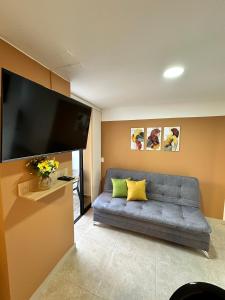uma sala de estar com um sofá e uma televisão de ecrã plano em Apartamento en Laureles cerca a la 70 y Estadio - 702 em Medellín