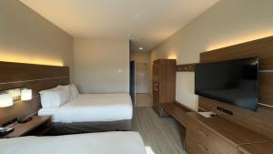 a hotel room with two beds and a flat screen tv at Holiday Inn Express Hotel & Suites Marina, an IHG Hotel in Marina