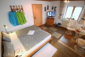 a room with a bed and a tv in it at Bäriger Urlaub mit viel Herz in Bad Bayersoien