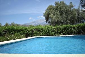een blauw zwembad met een berg op de achtergrond bij Ferienhaus mit Privatpool für 4 Personen ca 120 qm in Corumbela, Andalusien Costa del Sol in Sayalonga