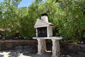 un alimentador de aves de piedra sentado en un jardín en Ferienhaus mit Privatpool für 4 Personen ca 120 qm in Corumbela, Andalusien Costa del Sol, en Sayalonga