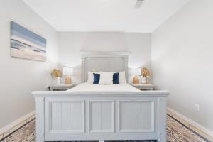 Dormitorio blanco con cama blanca y almohadas azules en Villa South, en Gulf Breeze