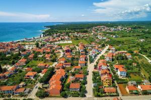 eine Luftblick auf eine Stadt mit Häusern und das Meer in der Unterkunft Strandnahe Wohnung mit überdachter Terrasse und Garten in Fažana
