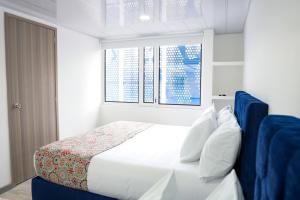 a bedroom with a white bed and a window at Hotel Sky Blue in Manizales +6 photos