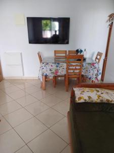 ein Esszimmer mit einem Tisch und Stühlen sowie einem TV in der Unterkunft Super et nouvel appart proche de la plage in Temara