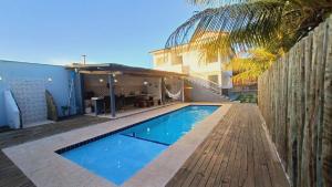 una piscina frente a una casa en Casa com 4 quartos, piscina e área gourmet, en Porto Seguro