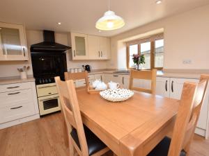 a kitchen with a wooden dining room table with chairs at 2 bed in Clovelly 56720 in Woolfardisworthy