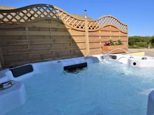 a hot tub in a backyard with a wooden fence at 2 bed in Clovelly 56720 in Woolfardisworthy