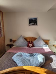 ein Schlafzimmer mit einem Bett mit einem Herzkissen drauf in der Unterkunft Große Ferienwohnung in Nesselwängle in Nesselwängle