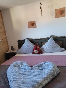 - une chambre avec 2 lits dotés d'oreillers bleus et blancs dans l'établissement Große Ferienwohnung in Nesselwängle, à Nesselwängle