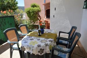 una mesa y sillas con una mesa y un jarrón. en Ferienwohnung für 4 Personen ca 45 qm in Poljica bei Trogir, Dalmatien Kaštela und Umgebung, en Poljica