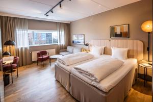 um quarto de hotel com uma cama grande e um sofá em Scandic Sydhavnen em Copenhaga