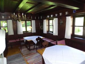 a dining room with a table and chairs and windows at Ferienhaus für vier Personen mit Sitzgelegenheit in Schöllnach