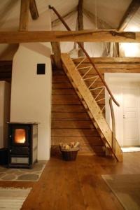 escalera en una habitación con chimenea y fogones en Charmantes Ferienhaus in der Wildnis Lapplands en Blattnicksele