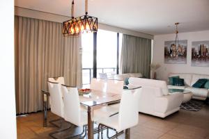 a dining room and living room with a table and chairs at The Luxury Apartment in San Salvador