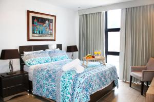 The Luxury Apartment في سان سلفادور: غرفة نوم بسرير وطاولة عليها فاكهة