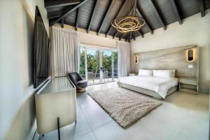 een slaapkamer met een bed, een stoel en een raam bij Paradise Villa in La Romana