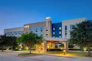 a building with a parking lot in front of it at Home2 Suites Dallas-Frisco in Frisco