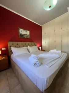 een slaapkamer met een groot wit bed met rode muren bij Xplore Xpress • Penthouse in Tirana