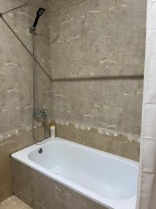 uma banheira na casa de banho com um chuveiro em Xplore Xpress • Penthouse em Tirana