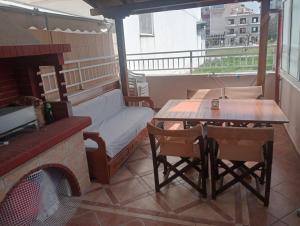 a balcony with a couch and a table and a fireplace at Hara's house in Nei Poroi