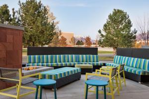 eine Terrasse mit Sofas, Stühlen und einer Feuerstelle in der Unterkunft Home2 Suites by Hilton Salt Lake City/Layton in Layton