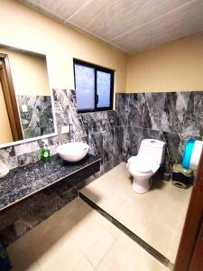 łazienka z toaletą i umywalką w obiekcie Hotel Los Algarrobos w mieście Puerto Baquerizo Moreno