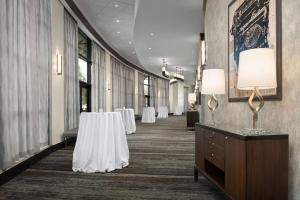 a hallway with tables and chairs in a building at Embassy Suites Springfield in Springfield