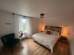 1 dormitorio con 1 cama, 1 silla y 1 ventana en Gite - La ruée vers l'orge en Trois-Rivières