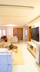Villa María luxury en Miches في Miches: غرفة معيشة مع أريكة وتلفزيون