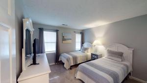 a bedroom with two beds and a flat screen tv at Two Bdrm Villa, True Blue, Golf Escape in Pawleys Island