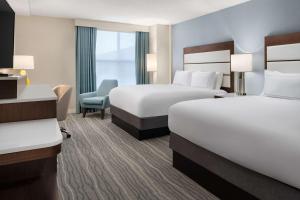 a hotel room with two beds and a chair at DoubleTree by Hilton Norfolk Airport in Norfolk +20 photos