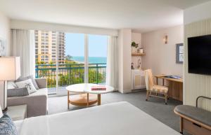 a living room with a view of the ocean at The Singer Oceanfront Resort, Curio Collection by Hilton in Palm Beach Shores
