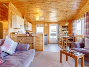 キンロスにある2 Bed in Loch Leven 82297のリビングルーム(ソファ、テーブル付)、キッチンが備わります。