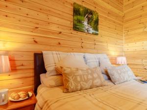 a bed in a room with a wooden wall at 2 Bed in Loch Leven 82297 in Kinross