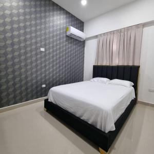 sypialnia z białym łóżkiem z czarnym zagłówkiem w obiekcie Lujoso PH en DT, área de trabajo y GYM, 1BR w mieście Santo Domingo