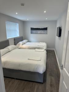 een slaapkamer met 2 bedden en een tv aan de muur bij Smeaton street rooms in Liverpool