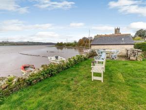 a table and chairs sitting on the grass next to a river at 4 Bed in Bere Alston RTIDE in Tamerton Foliot