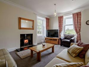 a living room with a couch and a fireplace at 3 Bed in Biggar 82924 in Biggar