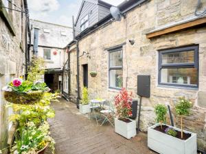 an alley with potted plants on the side of a building at 2 Bed in Rothbury 82238 in Rothbury